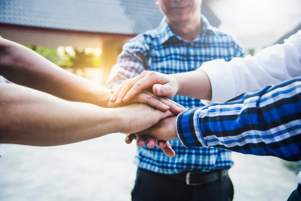 a group of people putting their hands together