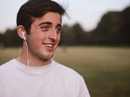 a man wearing earbuds and smiling