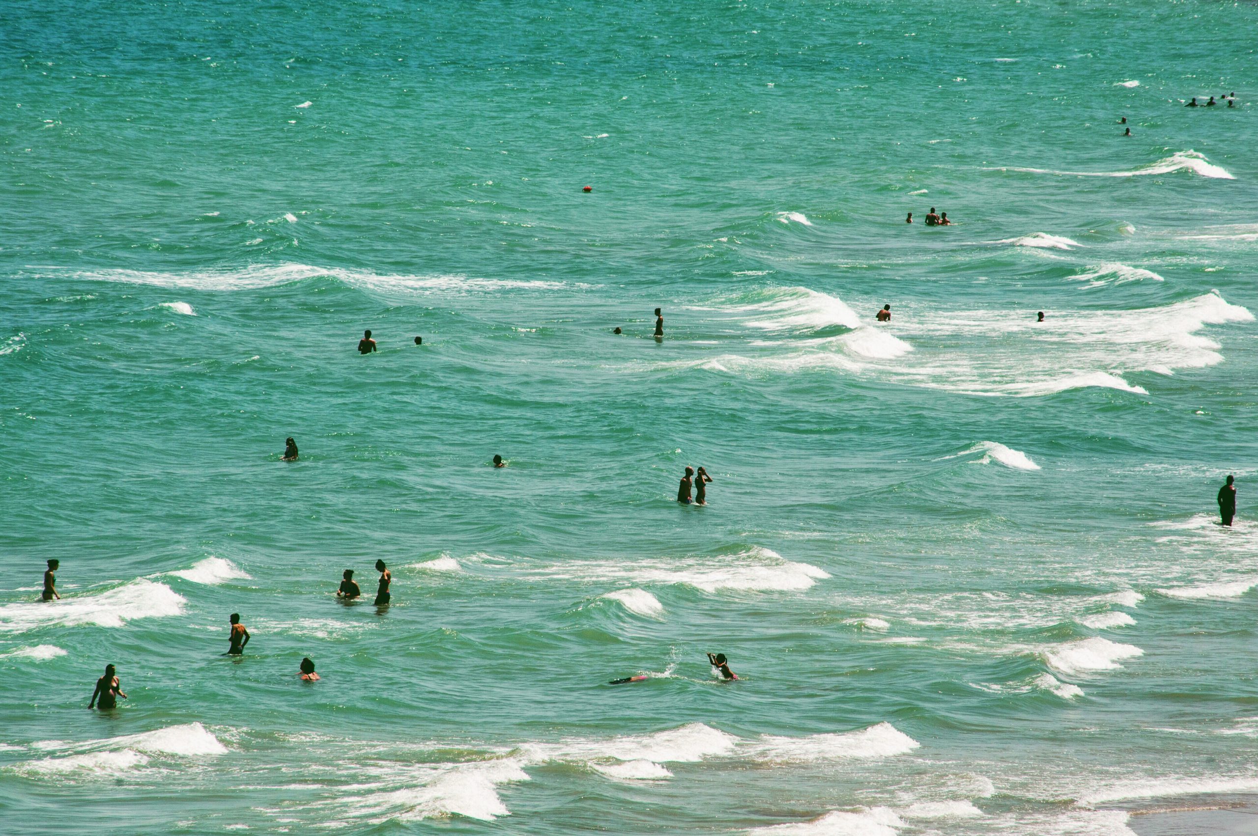 Beach day with waves and people in the water