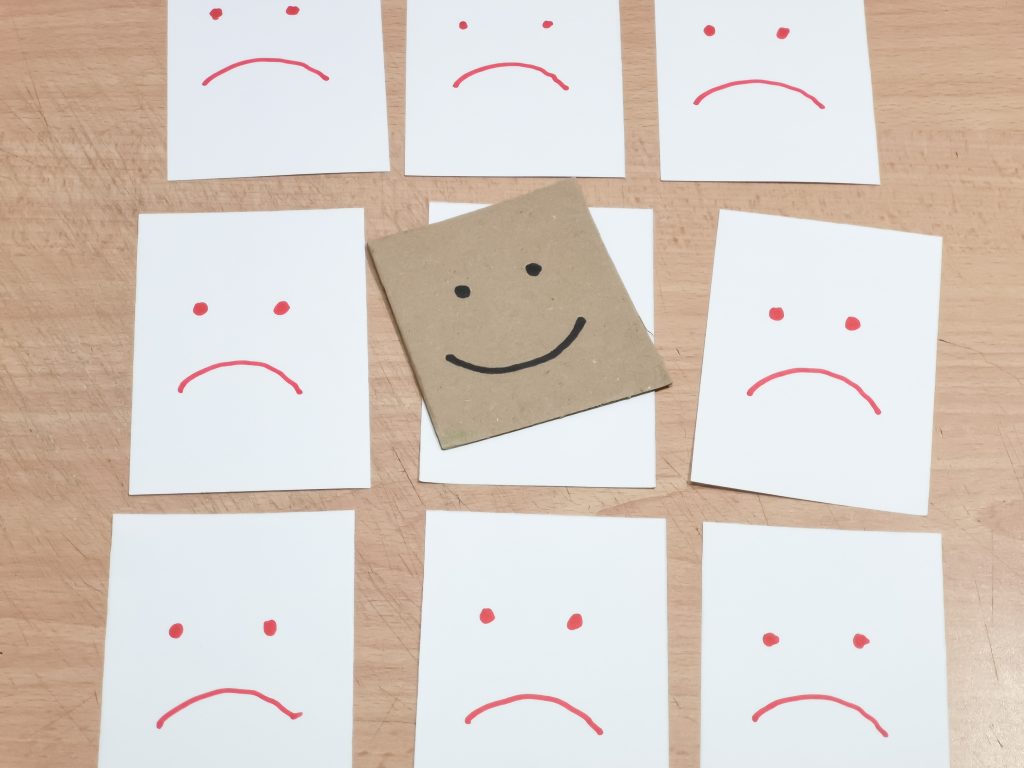 happy-face-drawn-on-paper-over-sad-face-papers